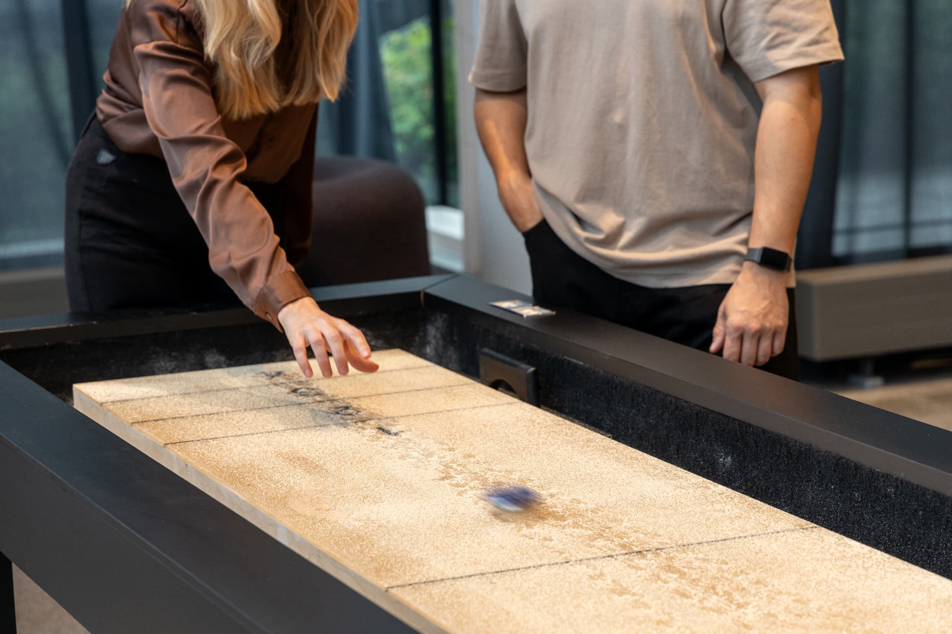 Colleagues playing shuffleboard at the gaming area