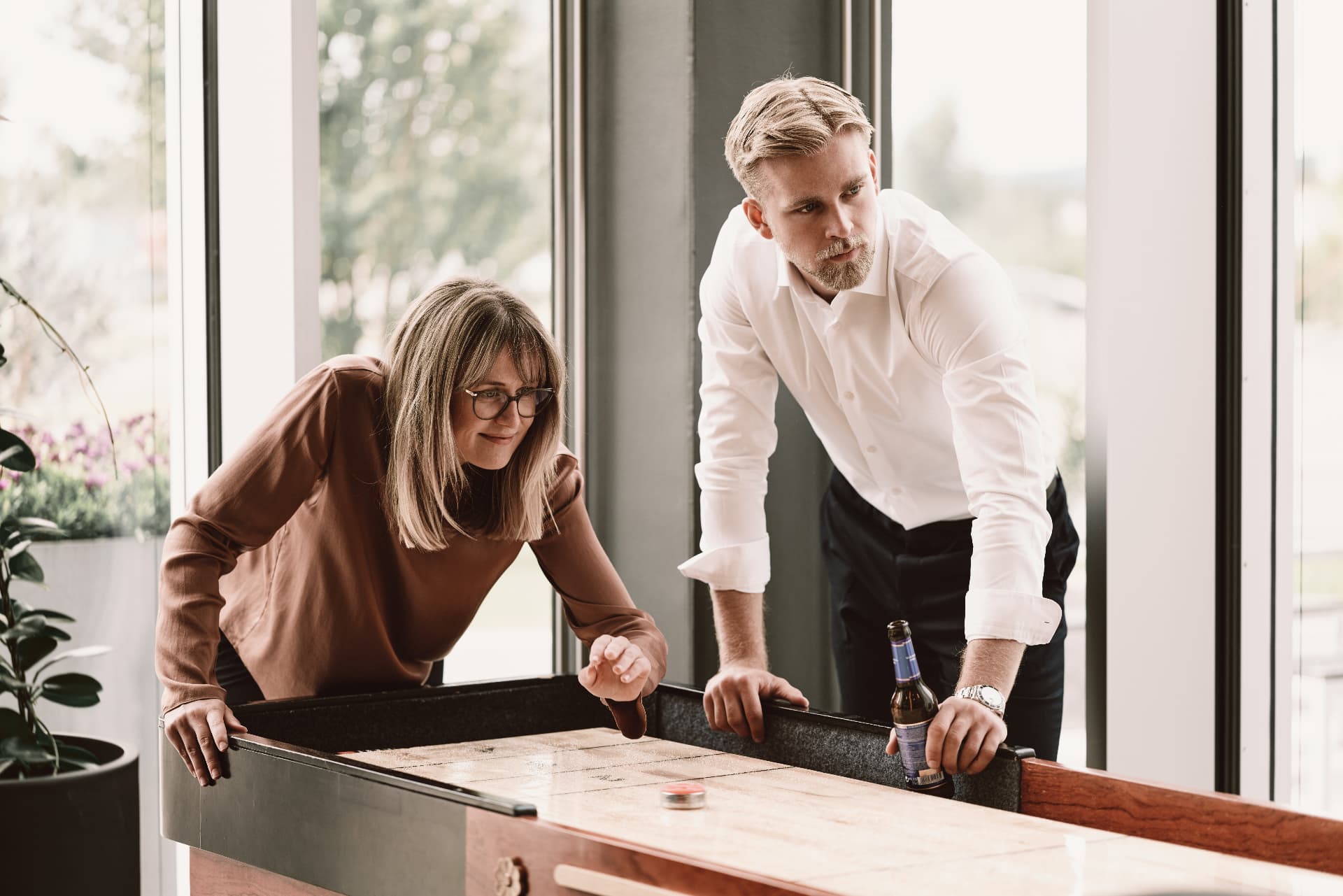 Colleagues playing shuffleboard in the gaming lounge